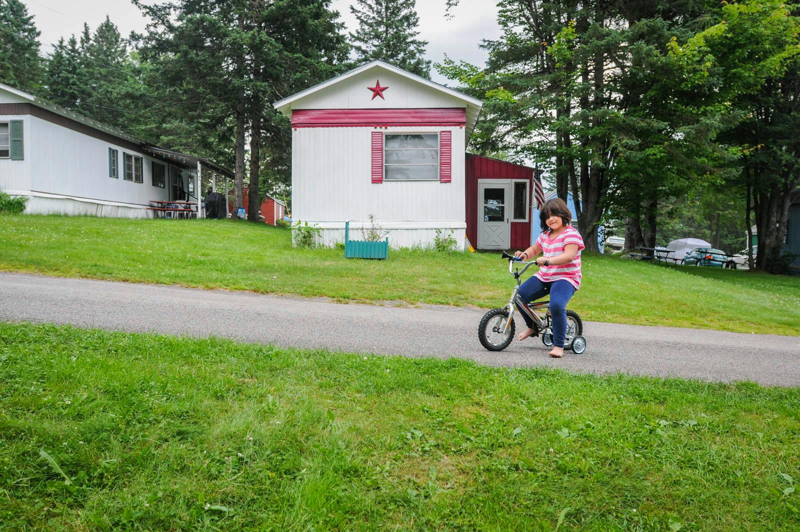 A young girl on a bicycle in a trailer park in Lancaster, New Hampshire.
