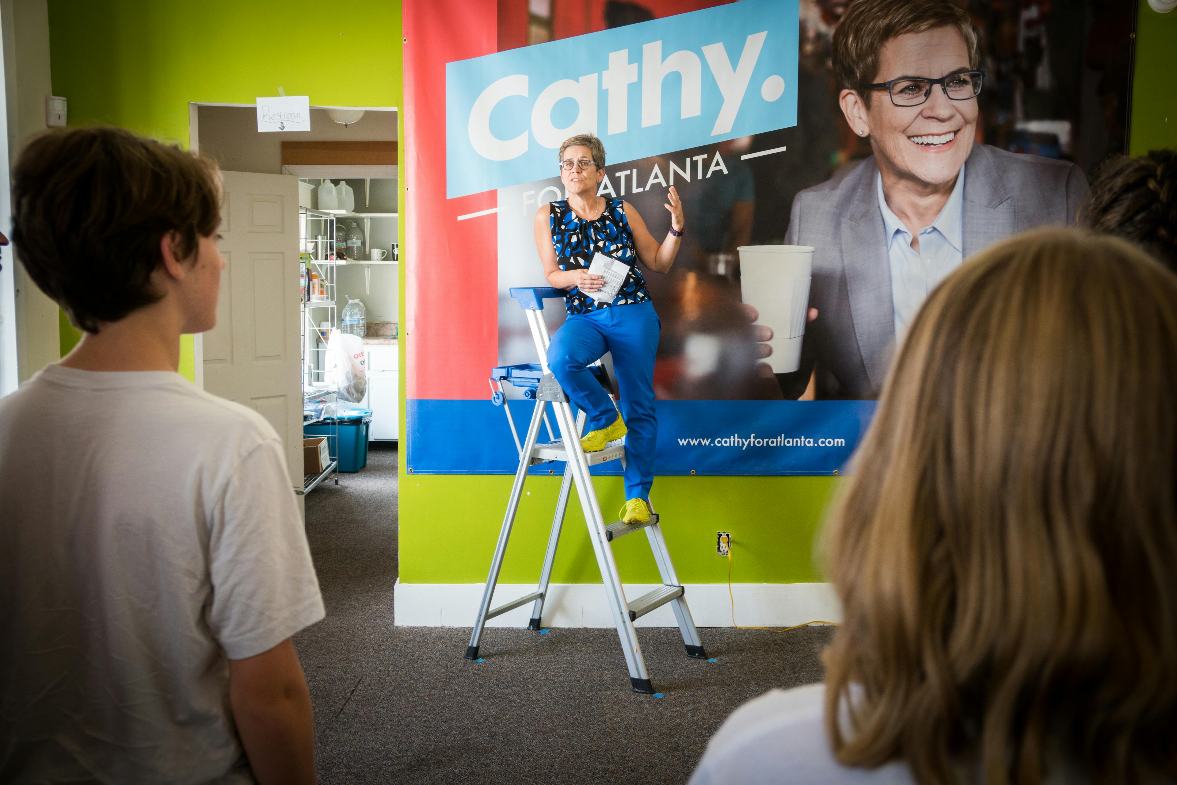 Atlanta mayoral candidate Cathy Woolard speaking from a ladder at the opening of her campaign office